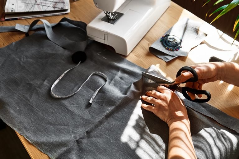 Woman,Cutting,Out,A,Pattern,Paper,In,Linen,Fabric