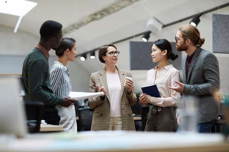 Portrait,Of,Successful,Businesswoman,Talking,To,Employees,While,Standing,In