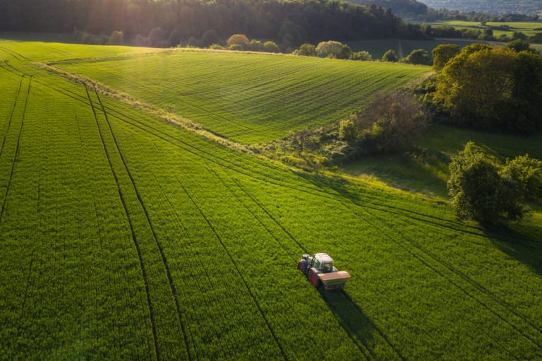 A farmer tills a field with his tractor